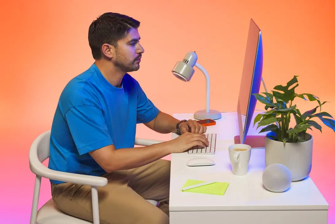 Small business owner working at his desktop computer in a bright home office