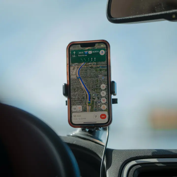 Phone on a car windshield mount giving turn-by-turn directions