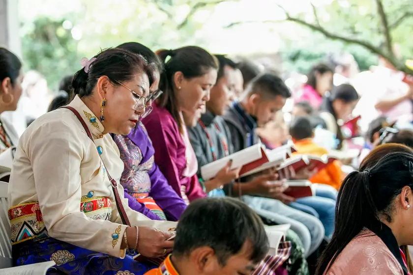 Neighbors of all ages reading together at an outdoor community event