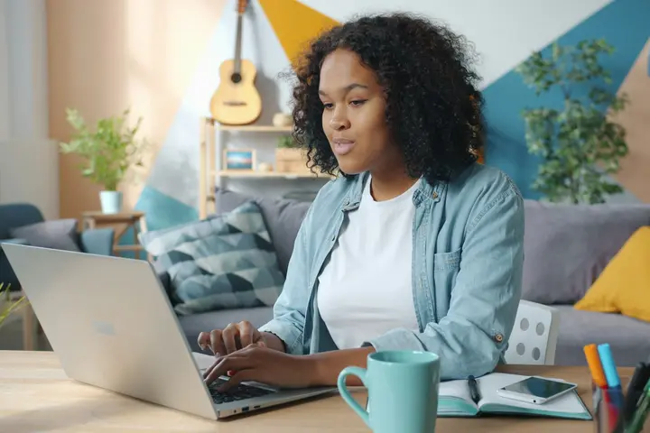 Business owner reviewing results on her laptop in a bright living room