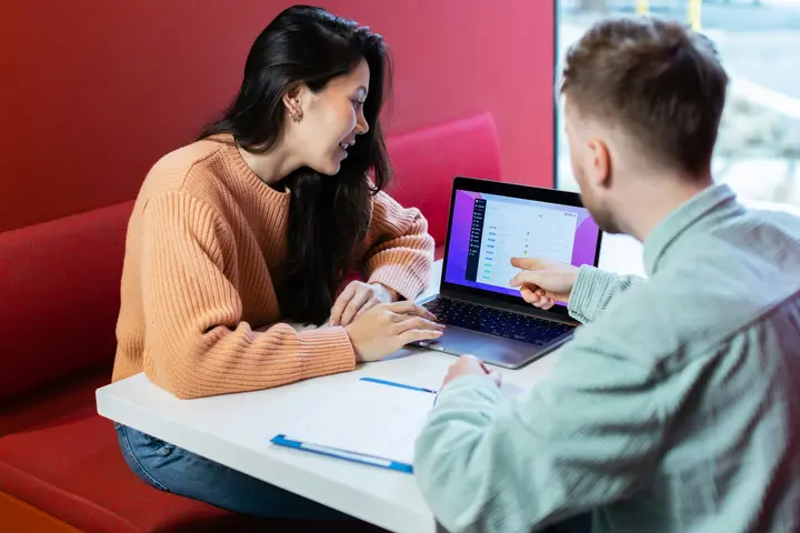 Marketing strategist walking a business owner through an email plan on a laptop