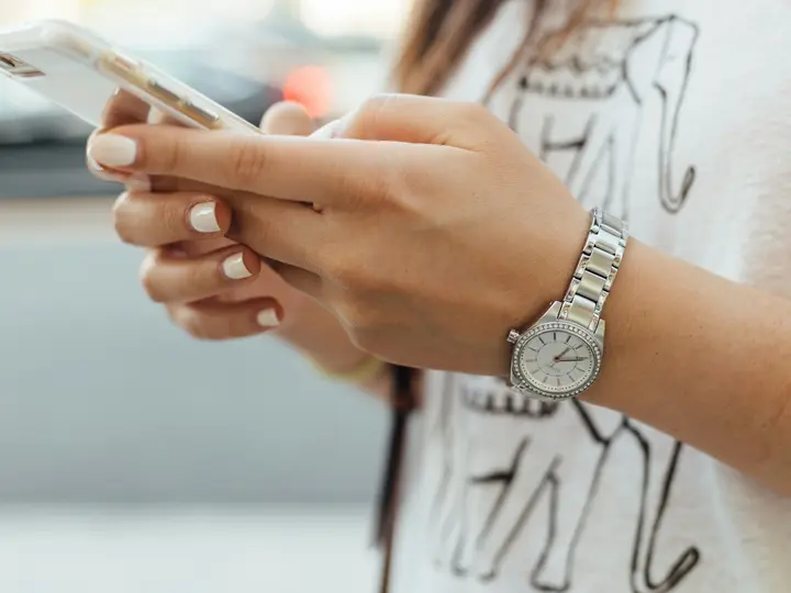 Close view of hands holding a phone and reading a text message
