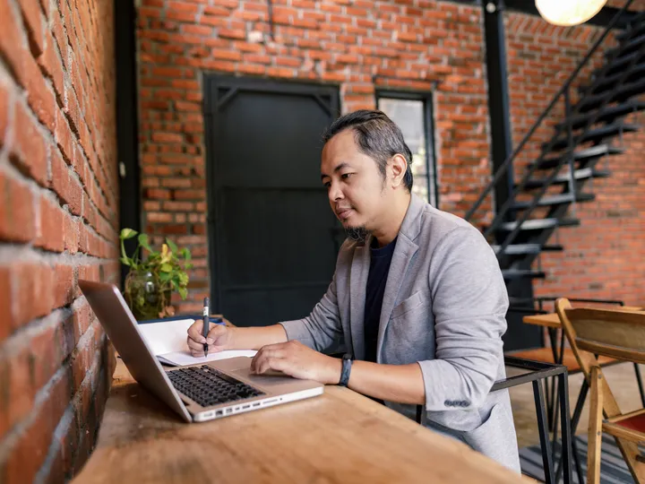 Certified Google Ads specialist working on campaigns at a laptop in a brick-walled office
