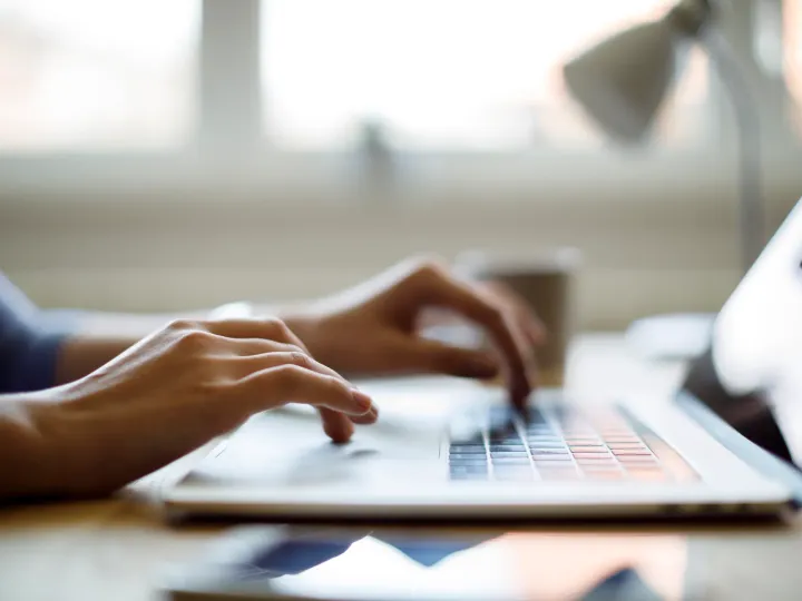 Hands typing on a laptop keyboard while setting up a new campaign feature