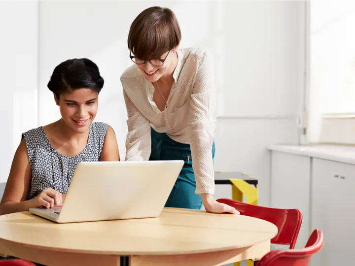 Two strategists reviewing a Google Ads account together at a laptop
