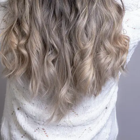 Back view of long wavy hair with a soft brunette to blonde balayage