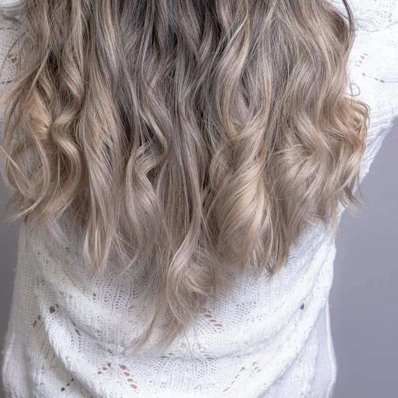 Email header photo: back view of long wavy hair with a soft brunette to blonde balayage