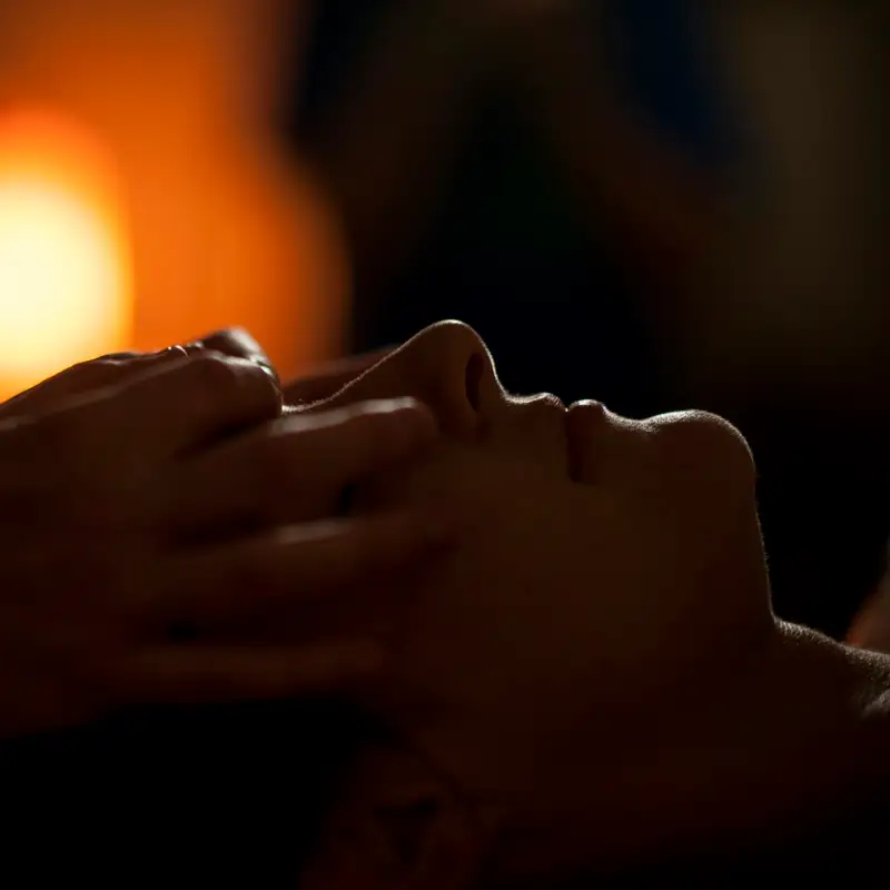 Email header photo: hands giving a relaxing facial massage in warm, dim light