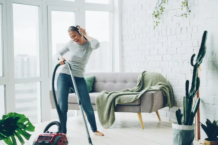 House cleaner vacuuming a bright, modern living room