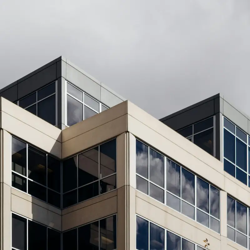 Email header photo: the upper floors of a finished office building with stone panels and tall windows under a grey sky
