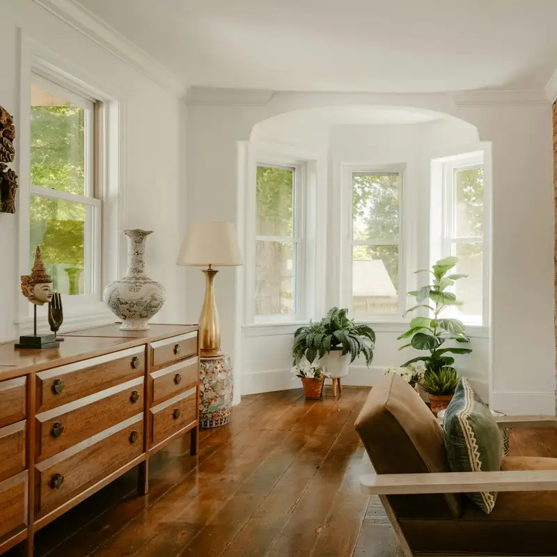 Email header photo: a restored living room in an older house with wood floors, a bay window, a brick fireplace and a wooden dresser