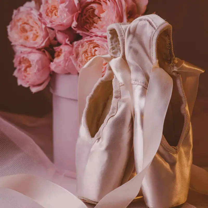 Email header photo: a pair of satin pointe shoes with ribbons beside a bouquet of pink peonies