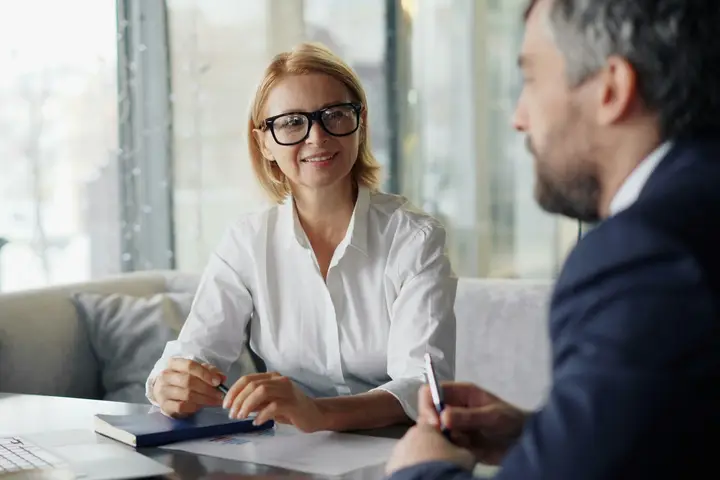 Financial advisor reviewing plans with a client at a laptop