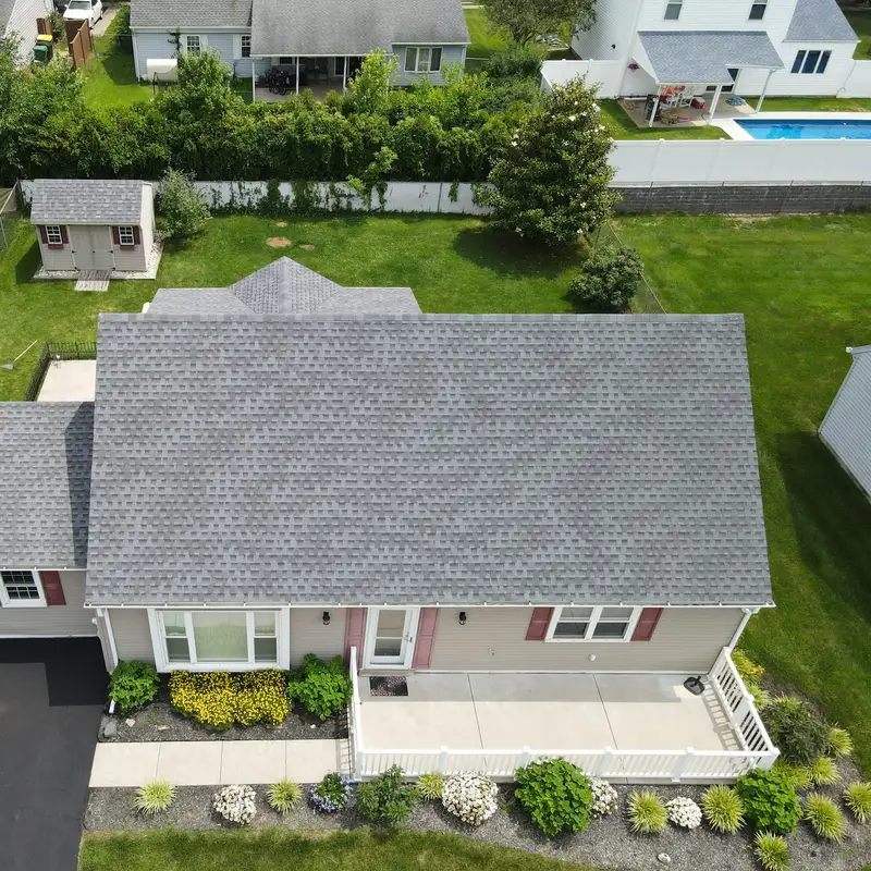 Email header photo: aerial view of a single-family home with a clean grey shingle roof, a green lawn and flower beds