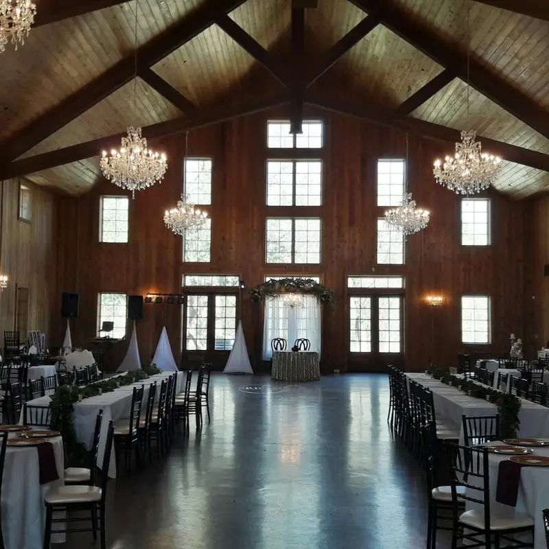 Email header photo: event hall with timber beams and crystal chandeliers set for a wedding reception