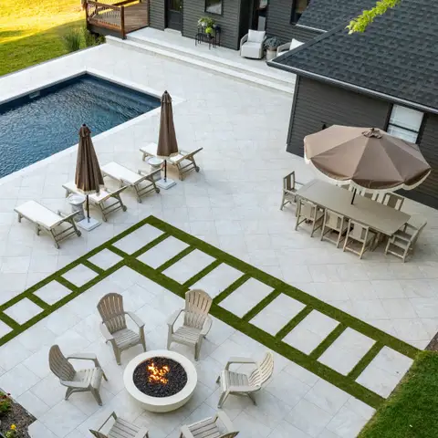 Backyard with a pool, a large stone patio, a fire pit circle and a dining area