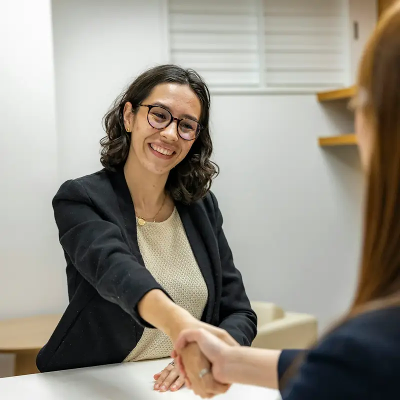 Email header photo: attorney shaking hands with a client across a table at a consultation