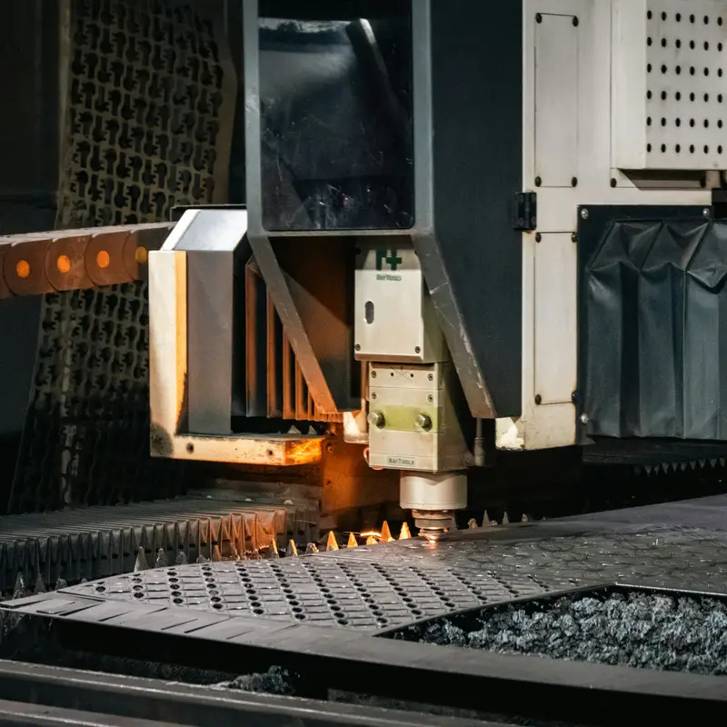 Email header photo: industrial laser cutter cutting a part from a steel sheet