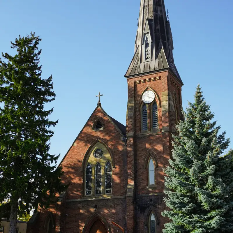 Email header photo: a red brick church with a tall steeple between evergreen trees under a clear blue sky