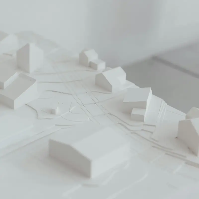 Email header photo: a white architectural site model showing low buildings, roads and lot lines on a sloped table