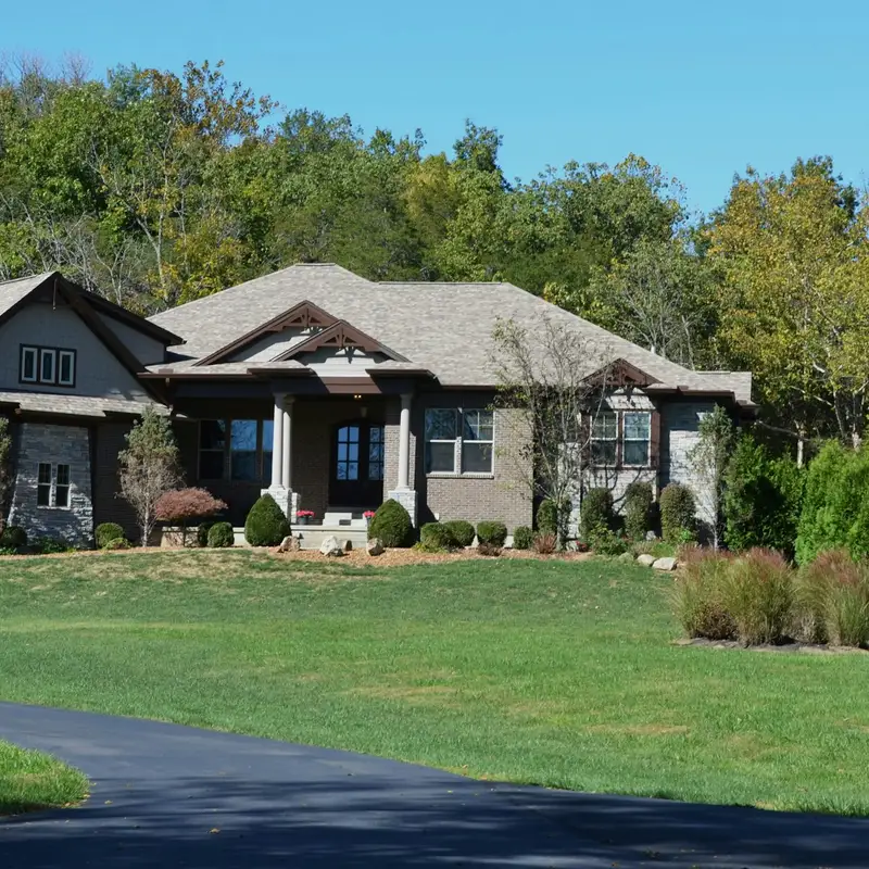 Email header photo: brick and stone house with a long driveway and a wide green lawn