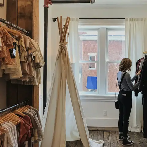 A woman looking through clothes on a rack in a boutique