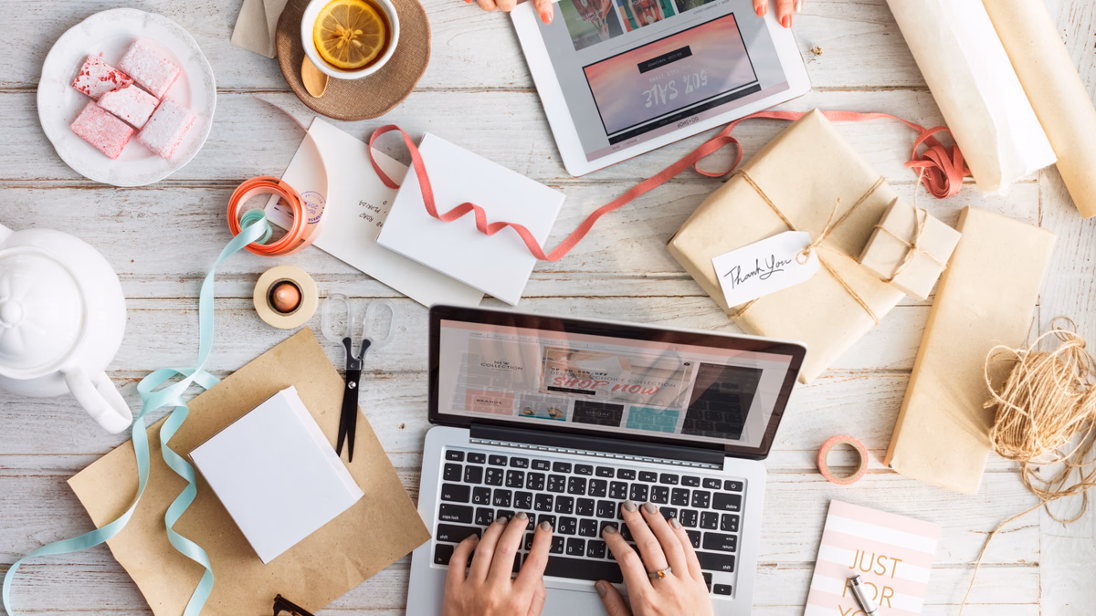 Ecommerce store owner organizing packaged retail orders and managing online product inventory with a laptop