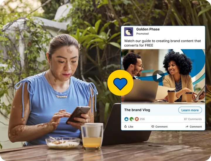 LinkedIn example of a promoted video post in the feed, shown on a phone held by a woman at a cafe table