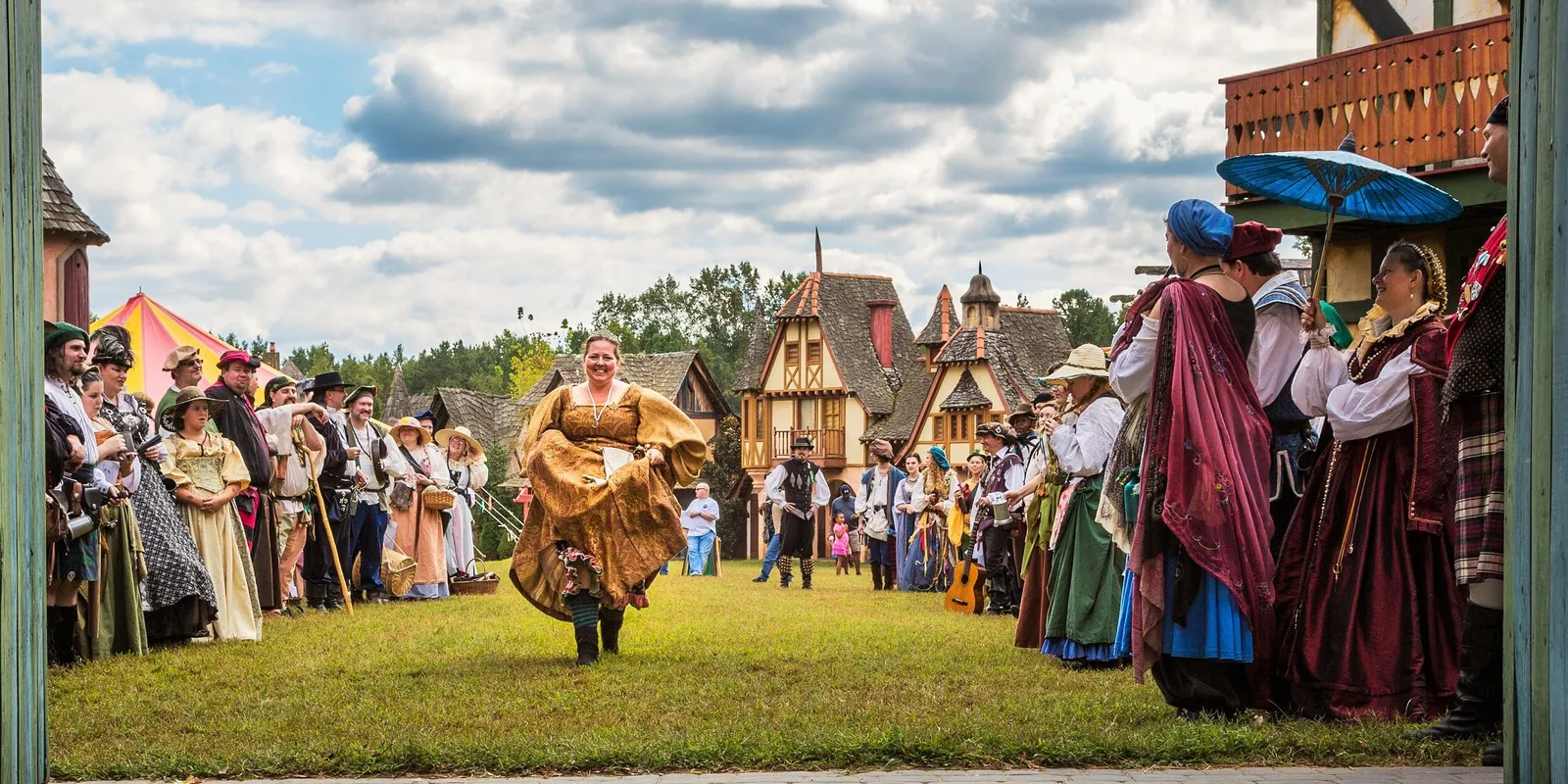 Villagers and costumed performers welcoming visitors through the gates at the Carolina Renaissance Festival