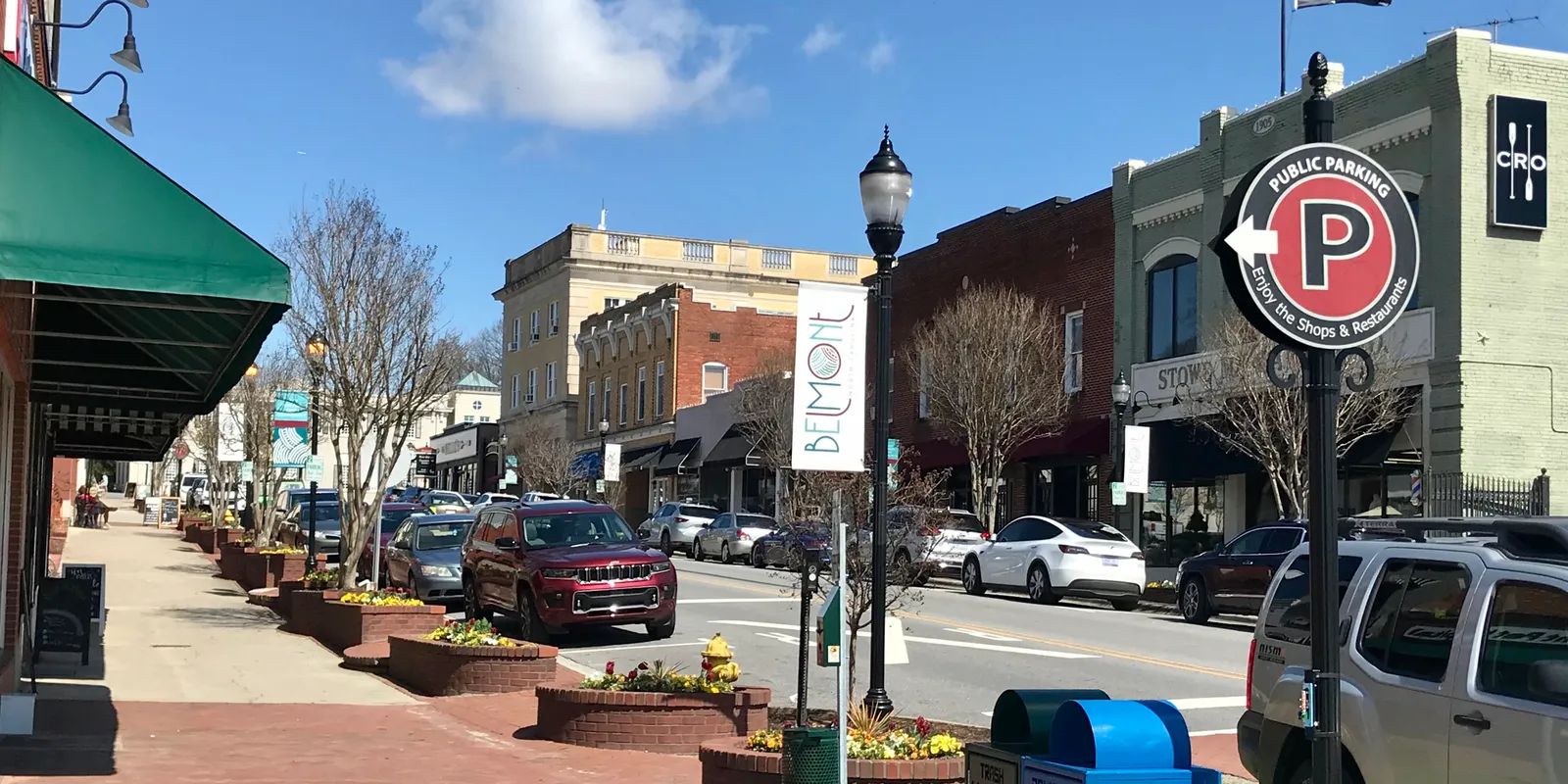 Pedestrian streetscape with storefronts and banners along historic Main Street in neighboring Belmont
