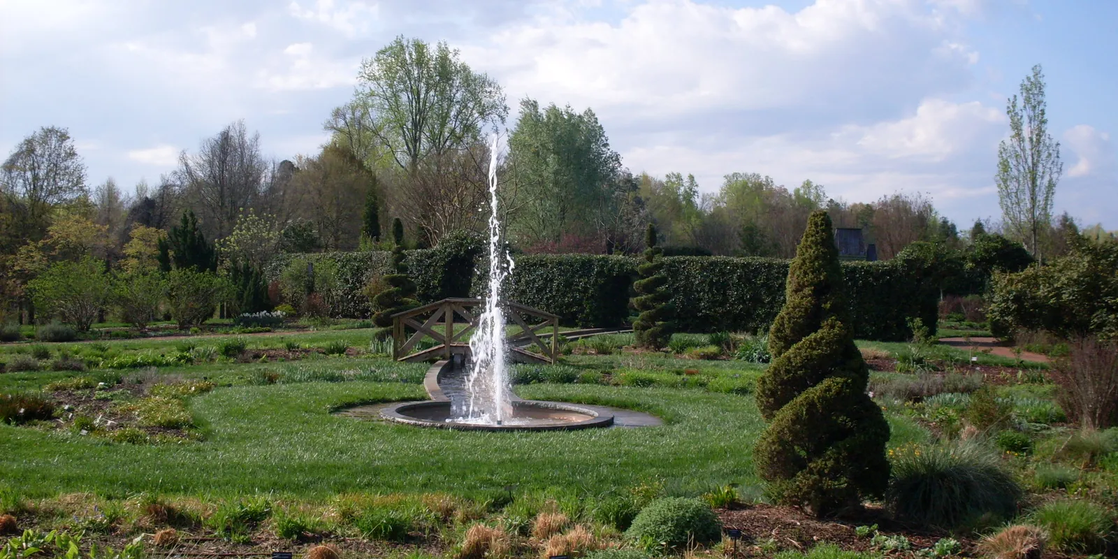 Ornamental water fountain and formal perennial garden beds at Daniel Stowe Botanical Garden