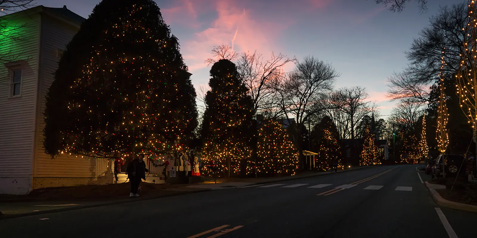 Historic mill town homes decorated with Christmas lights and festive holiday crowds in neighboring McAdenville