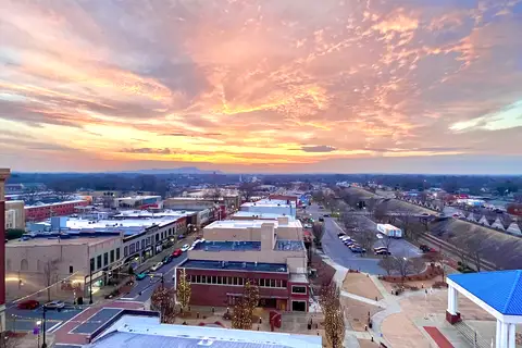 Aerial panorama of downtown Gastonia, North Carolina with streetscapes, civic buildings, and Piedmont horizon at sunset