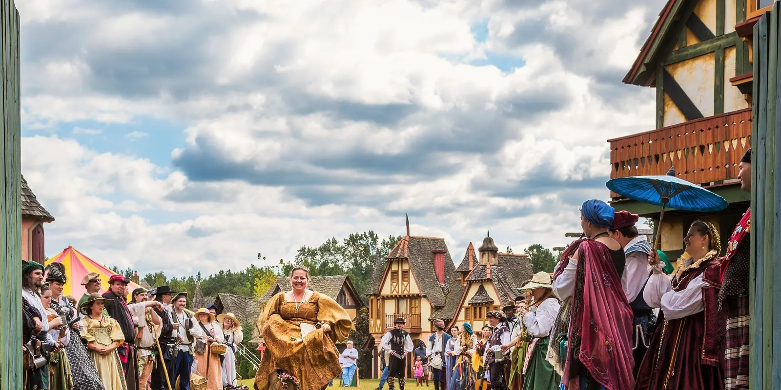 Villagers in costume welcoming guests through the gates of Fairhaven, the Carolina Renaissance Festival village
