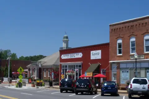 Historic brick storefronts and tree-lined streetscape of downtown Matthews, North Carolina