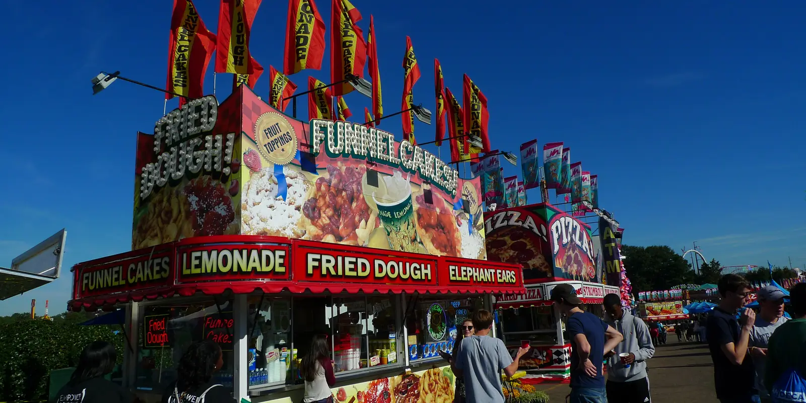 Carnival midway, exhibition tents, and ferris wheel at an evening agricultural fair in North Carolina