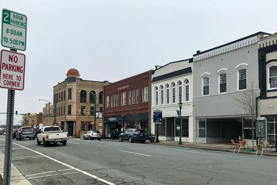 Commercial brick storefronts and tree-lined sidewalks along West Franklin Street in historic downtown Monroe