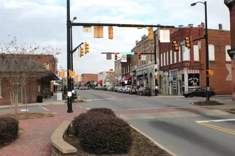 Historic brick storefronts and tree-lined sidewalks along North Main Street in downtown Mooresville, North Carolina