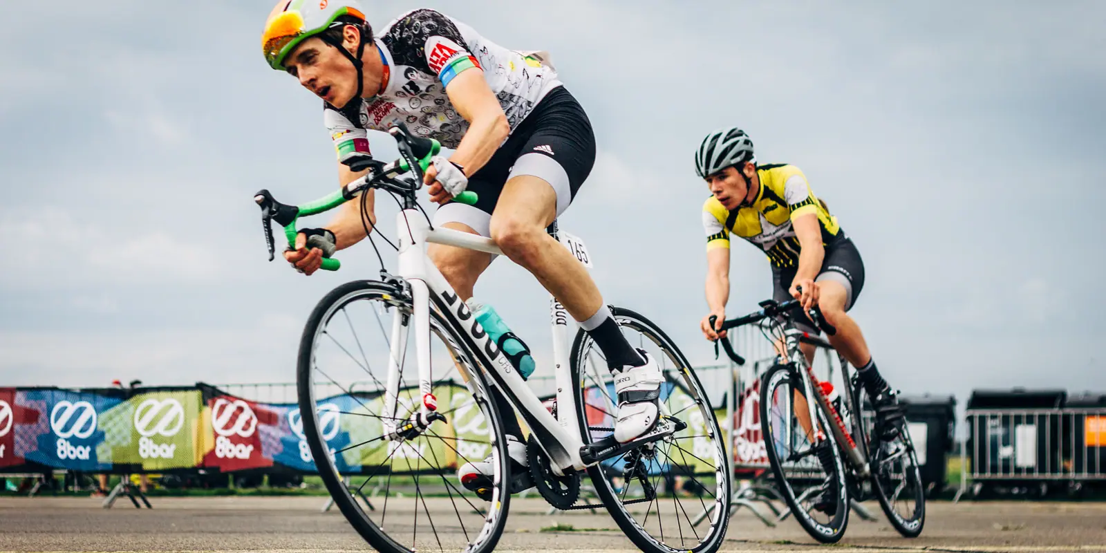Competitive road cyclists leaning sharply into a downtown street corner during the Belmont Criterium race