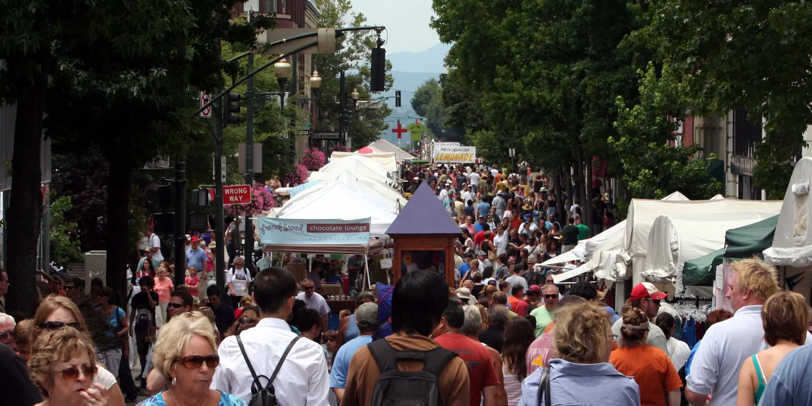 Crowds enjoying a vibrant outdoor street festival and vendor fair in downtown Belmont, North Carolina