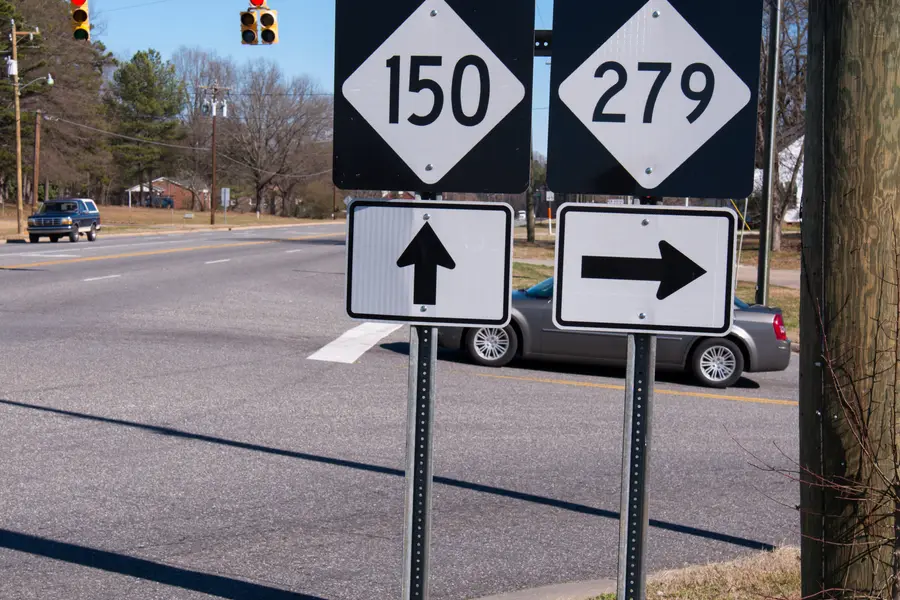 Highway intersection signage for NC Route 150 and NC Route 279 in Cherryville, representing the town's key commercial transportation crossroads