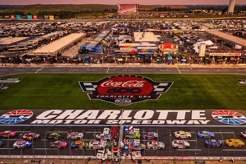 Aerial view of the Coca-Cola 600 starting grid, infield and grandstands at Charlotte Motor Speedway in Concord, North Carolina, at sunset
