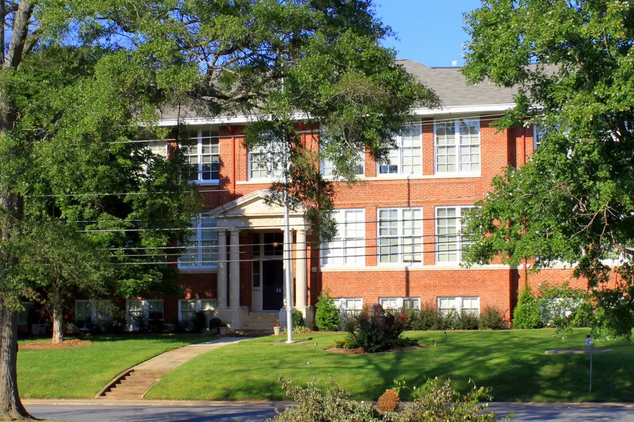 Historic red brick facade and portico of Mayworth School in Cramerton