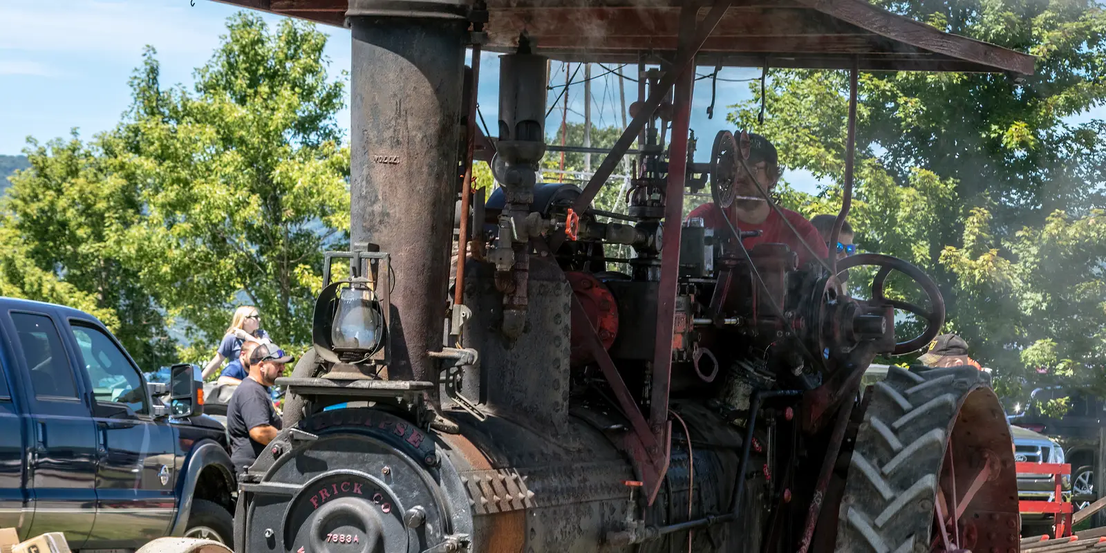 Historic steam-powered antique tractor operating at a regional outdoor agricultural festival