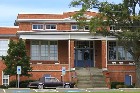 Historic brick facade and landscaped grounds of the Dallas Graded and High School building in the Dallas Historic District