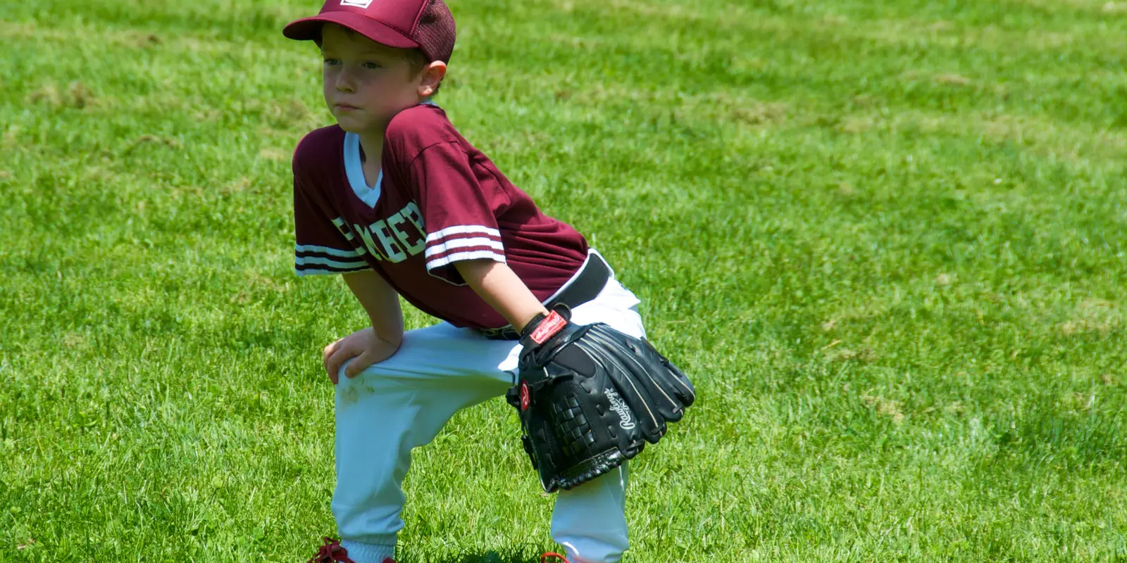 Young baseball players competing in community team athletics on an outdoor sports field