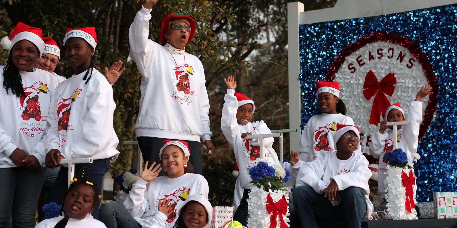 Families and community members gathered for an evening holiday parade along the street