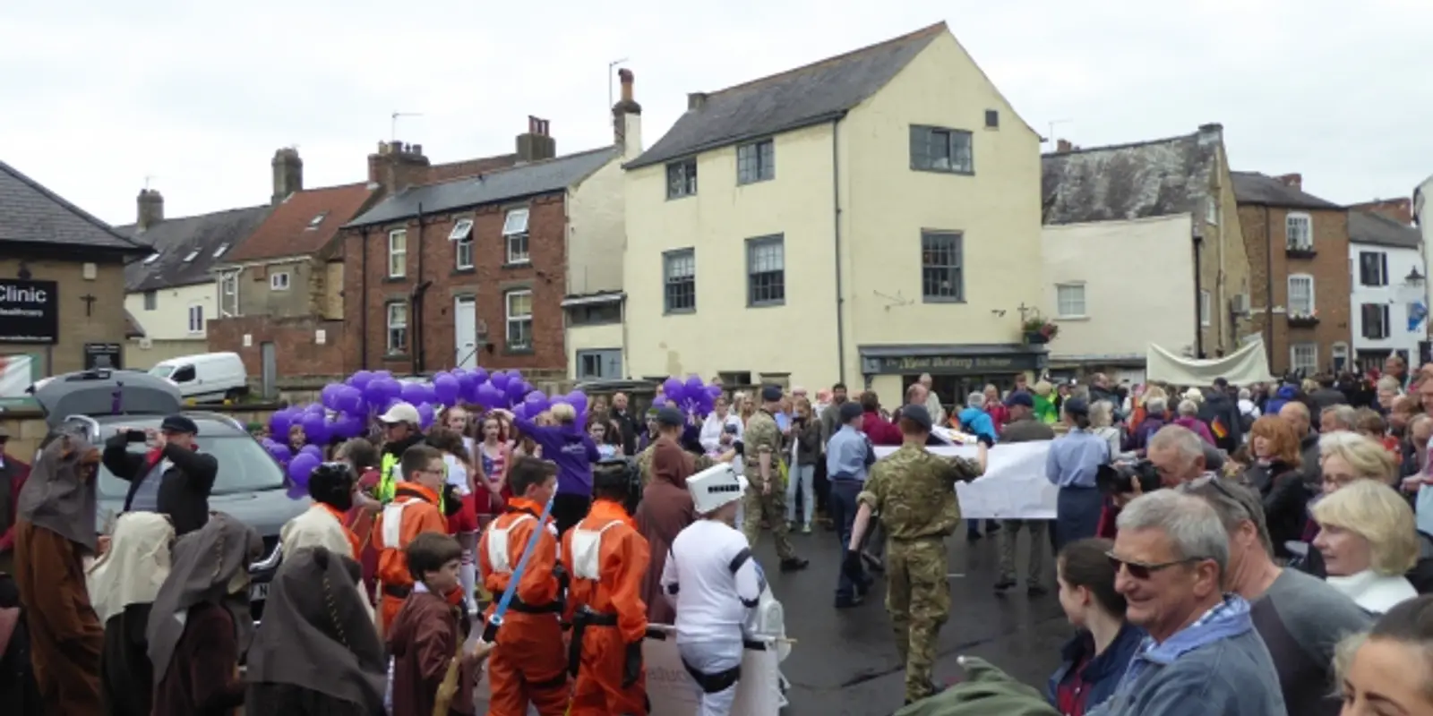 Costumed teams and custom-decorated racing beds lined up along the street for an annual community bed race festival