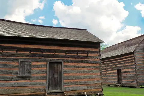 Historic log cabin and split-rail fence at the President James K. Polk State Historic Site in Pineville, North Carolina