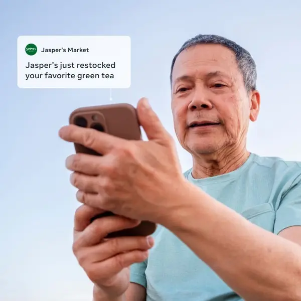 Customer reading a restock message from a local market on his phone